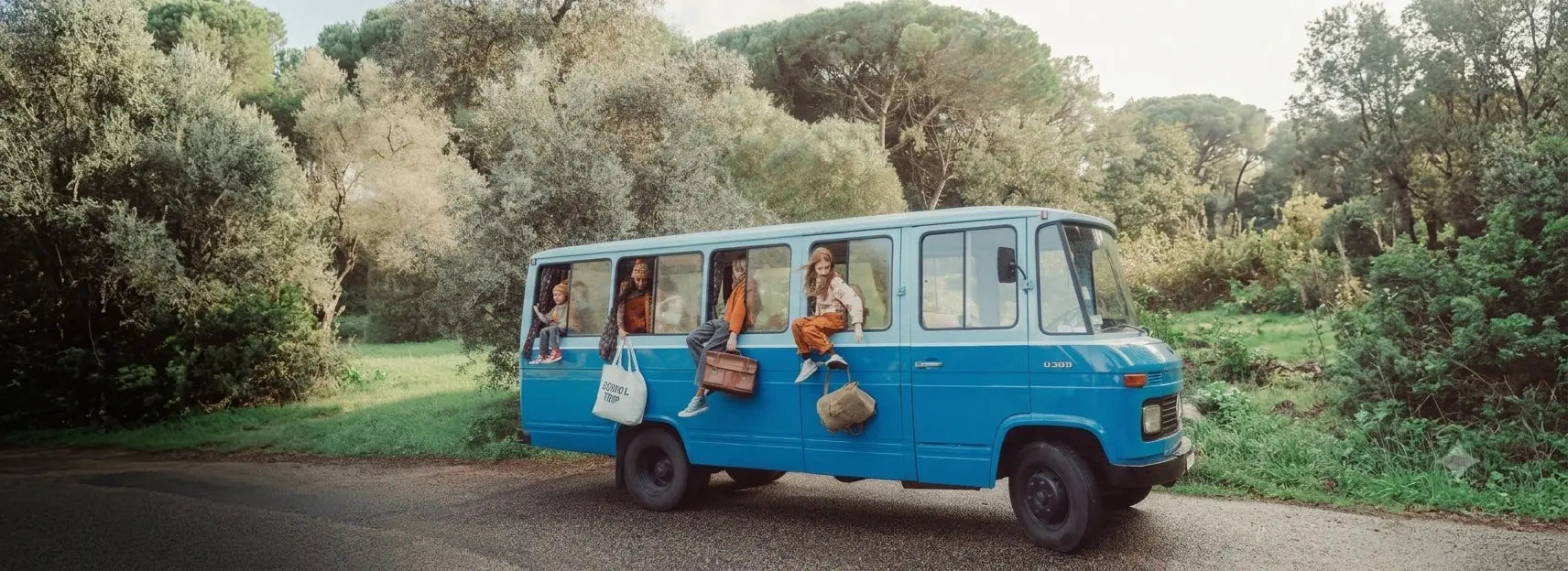 Dzieci w jesiennych ubraniach w oknach niebieskiego szkolnego autobusu